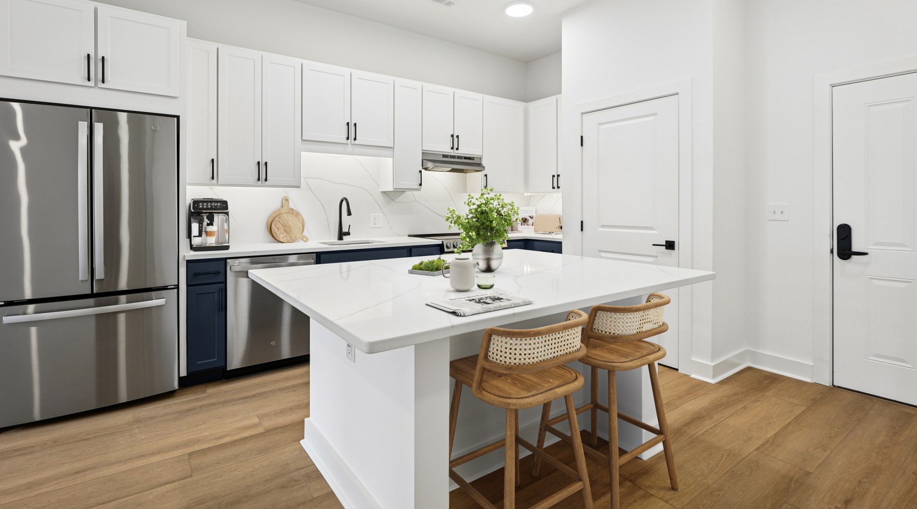 Newly renovated apartment featuring a white quartz kitchen island, stainless steel appliances, and white two-tone cabinetry