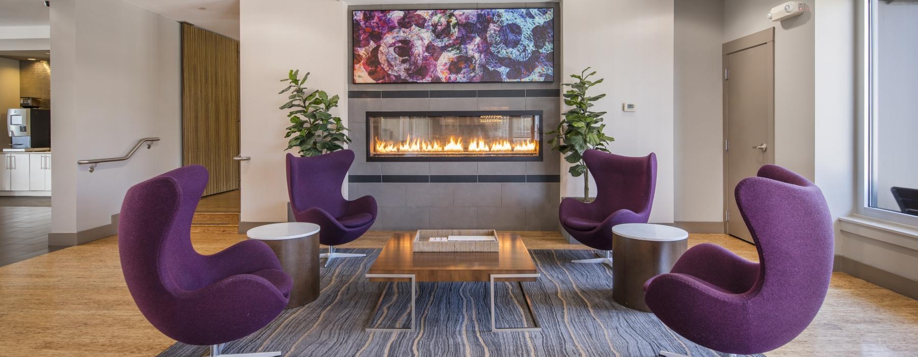 a room with purple chairs and a fireplace